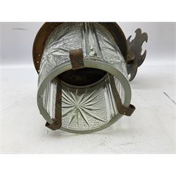 Wrought iron wall lantern with patterned glass shade of tapering cylindrical form, H29cm