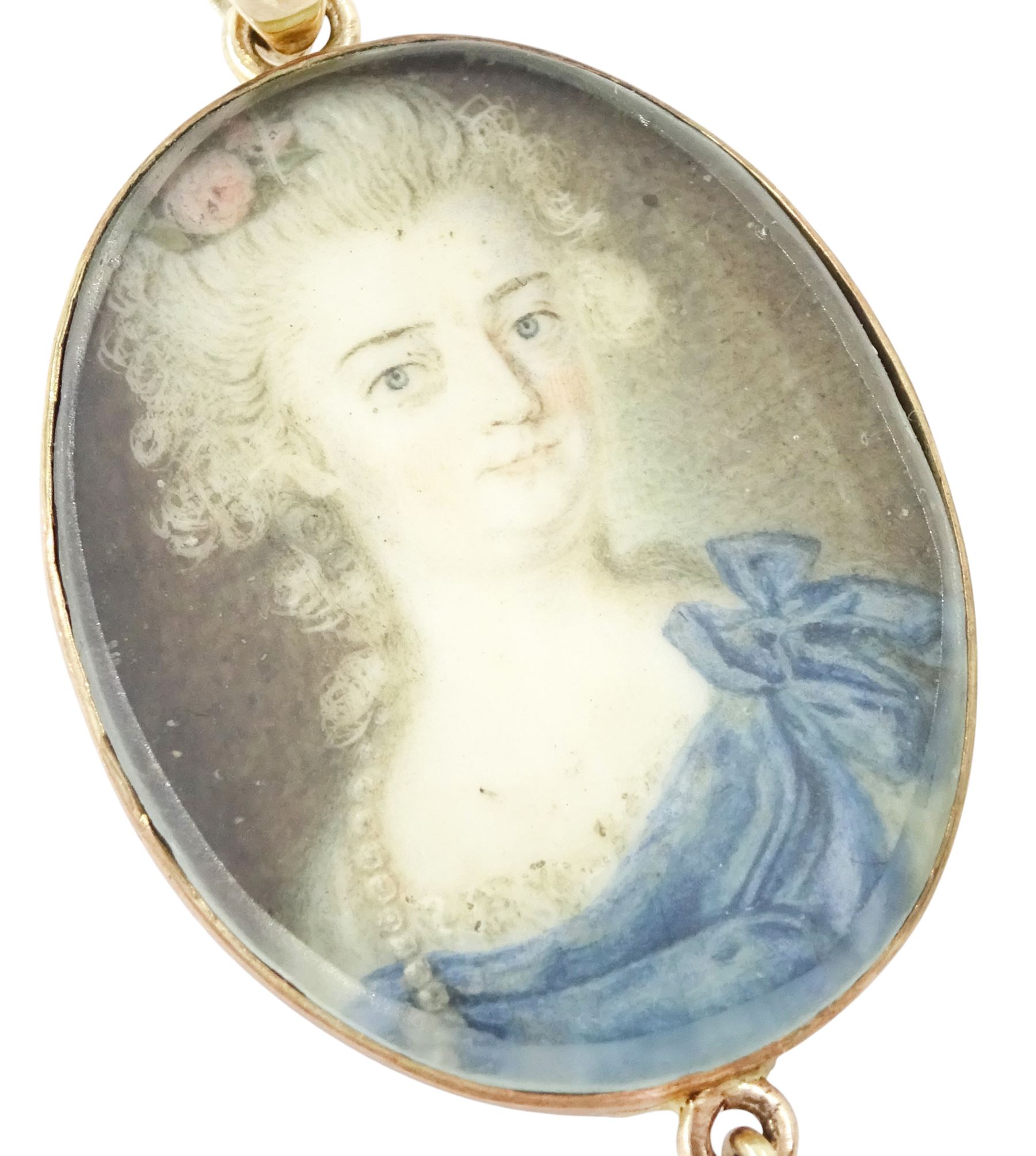 18th/ 19th century portrait pendant, set with an oval miniature of a woman wearing a blue dress on ivory, suspending a pearl drop. 
This lot has been registered for sale under Section 10 of the APHA Ivory Act
