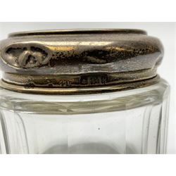 Hallmarked silver top dressing table jars, to include cut glass hobnail example with foliate engraved lid, another 20th century cut glass example with silver engraved screw thread lid, stamped H.S.M Herbert Scott Murdoch, with interior stopper and two smaller glass jars (4)