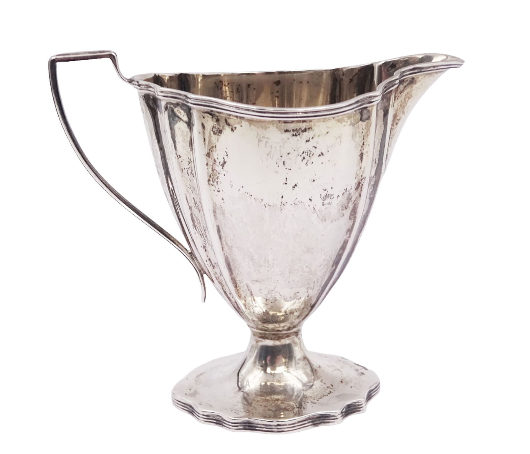 Edwardian silver cream jug, of fluted helmet form, with angular handle and upon shaped foot, hallmarked Birmingham 1905, maker's mark indistinct, together with a set of six Edwardian silver teaspoons and a pair of sugar tongs, all with scrolling embossed decoration and engraved monogram, hallmarked Joseph Rodgers & Sons, Sheffield 1903, within tooled leather fitted case, jug including handle H9cm 