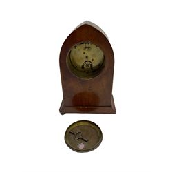 Mahogany “lancet”  shaped Edwardian bedside clock c1900 with contrasting stringing and a fan inlay motif, recessed brass baluster pillars to the case and a shallow moulded plinth raised on ball feet, with an enamel dial, Roman numerals, minute track and steel baton hands, spring driven “drum” movement with a platform escapement. With Key.

