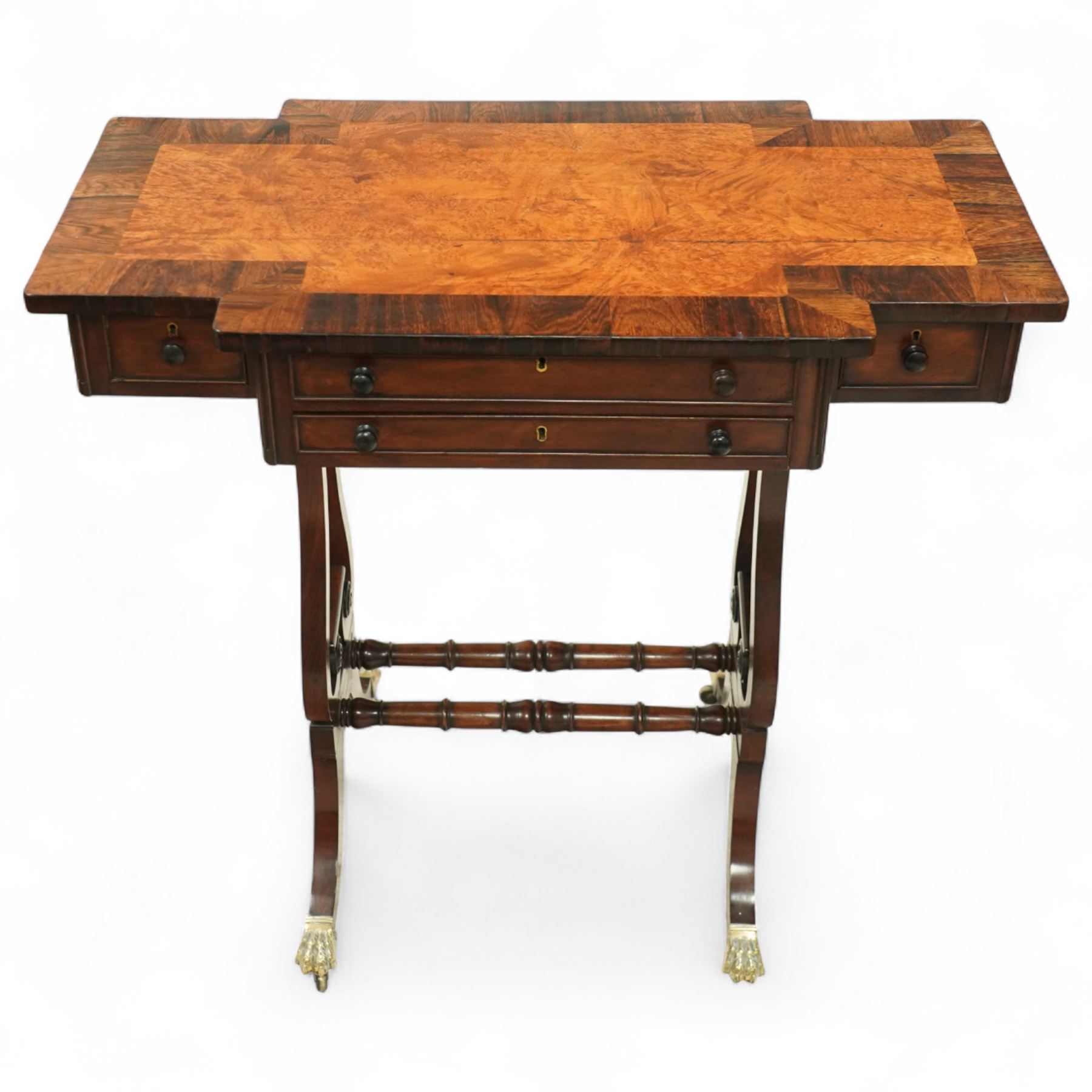 Early 19th century Regency burr elm work table, rosewood crossbanded top with notched corners above shaped end supports united by a turned stretcher, on brass paw feet and castors, stamped W Mason on lower turning