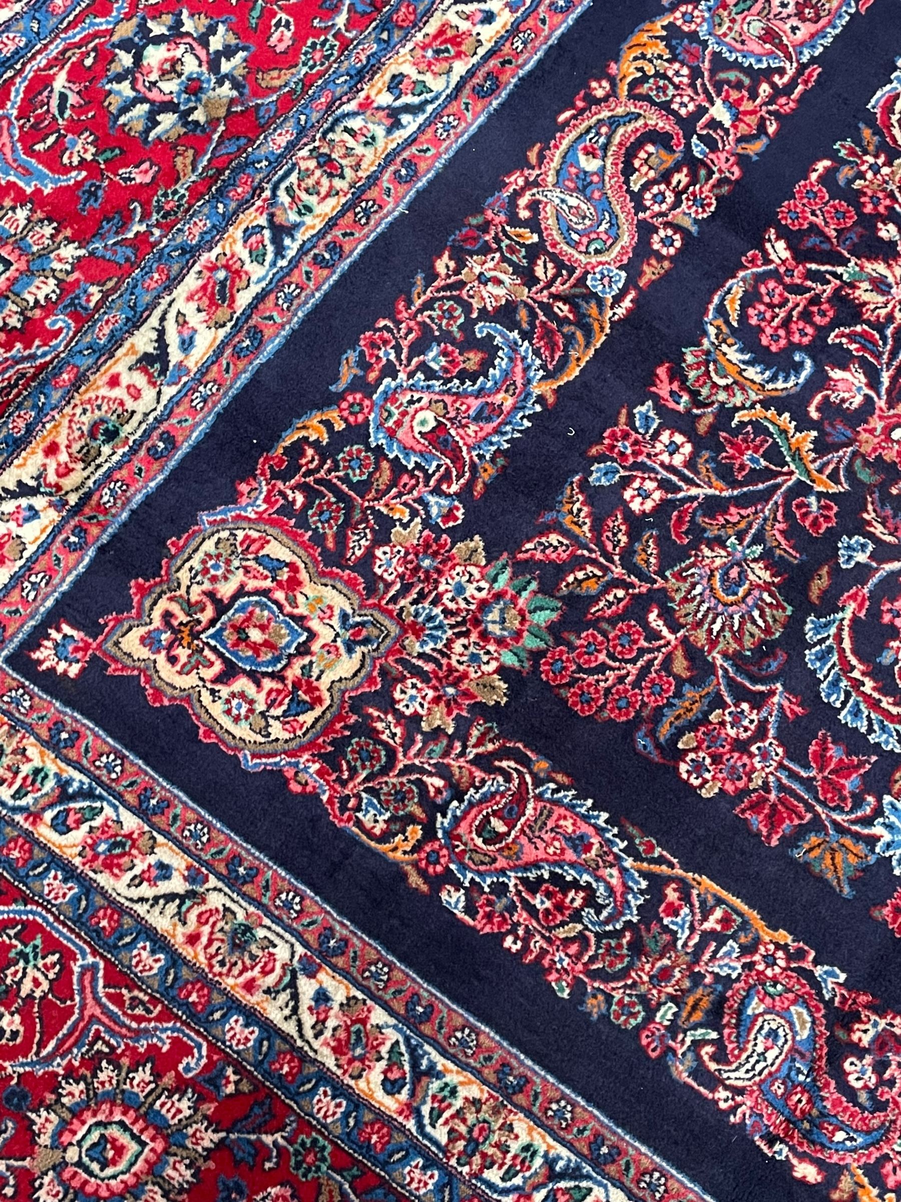 Persian Hamadan indigo ground carpet, the field decorated with central rectangle and outer band, overall floral pattern with cusped central medallion and surrounding leafy branches with palmettes, the border with scrolling branches decorated with further palmettes, within floral pattern guard stripes