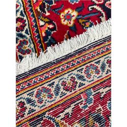 Persian indigo ground rug, the central crimson pole lozenge medallion surrounded by interlacing floral patterns, the main border with repeating plant motifs connected by scrolling branches