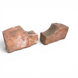 Pair of 19th century hewn and carved stone wall ends, the facias carved as shaped faux fielded panels