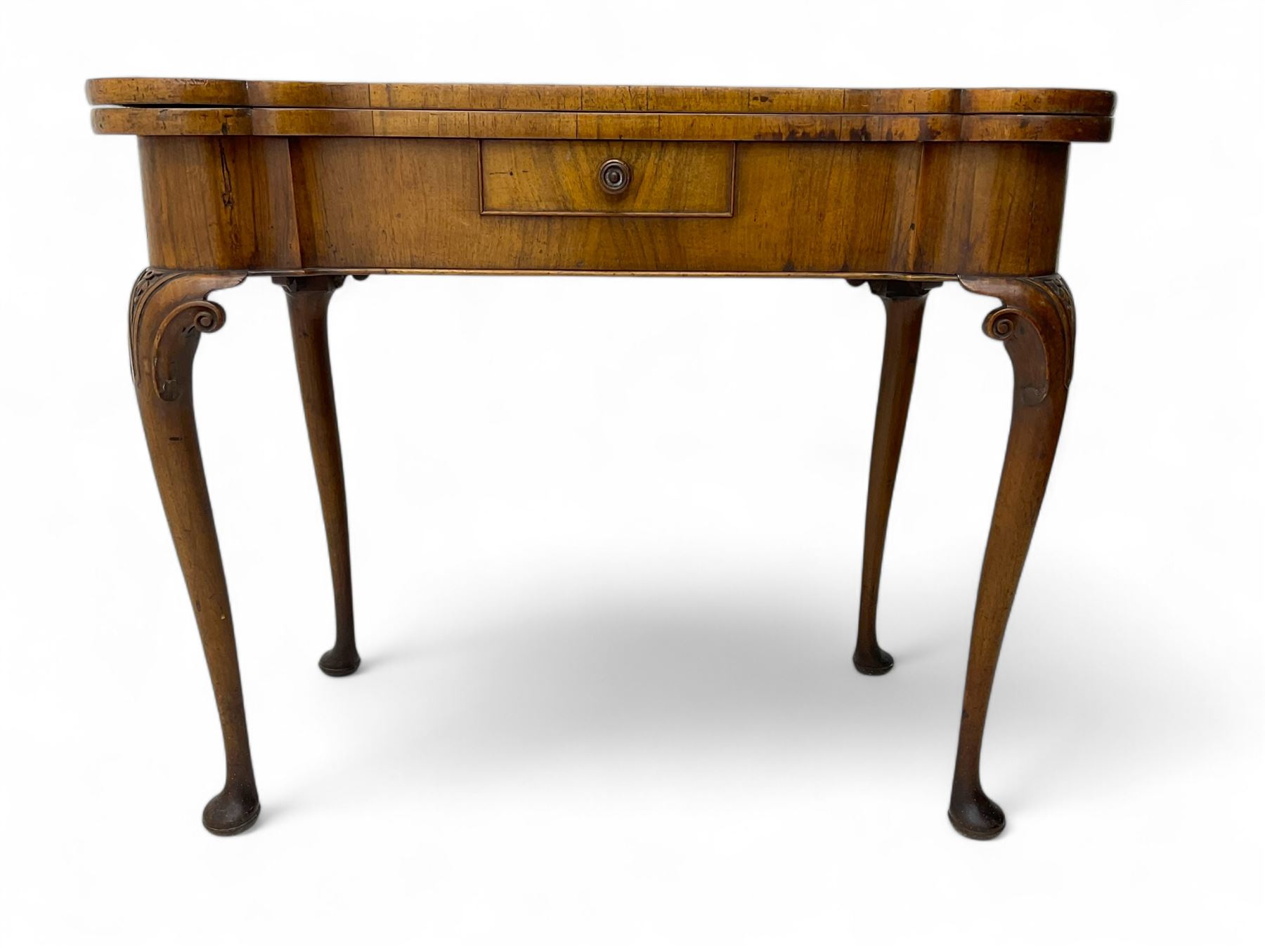 Georgian walnut fold-over card table, shaped rectangular top opening to reveal a baize-lined surface, supported by a concertina pull-out rear mechanism, frieze fitted with single drawer, raised on cabriole supports with foliate carvings terminating in pad feet