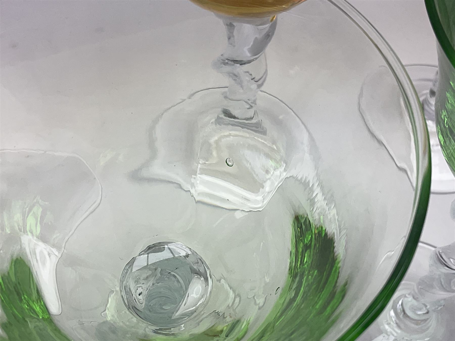 Ten coloured Adriana wine glasses by Abigails, to include blue, green, pink and yellow examples, each with part faceted bowl and twist stems, together with two similar orange examples with pulled stems, H24cm