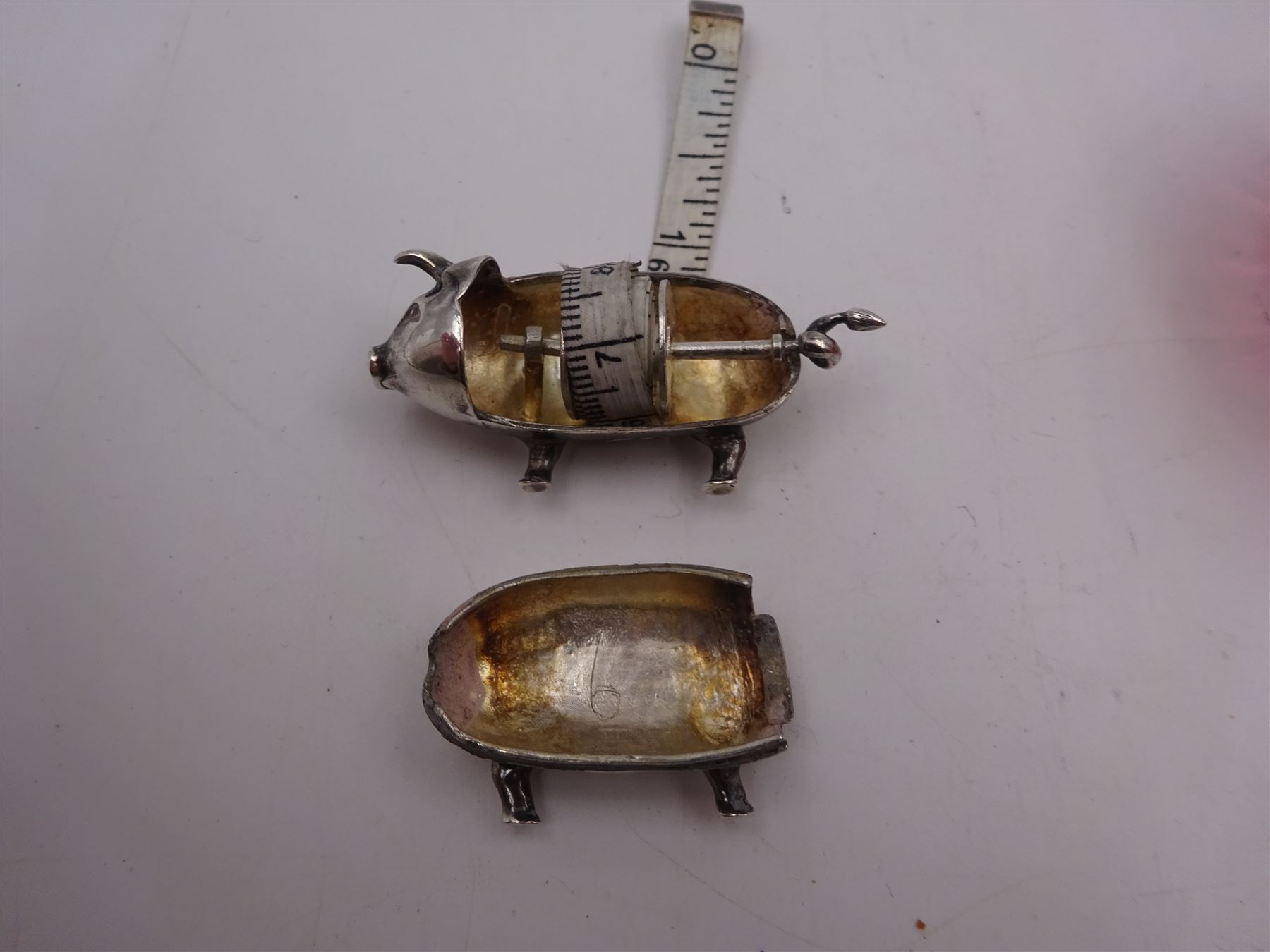 Modern novelty silver tape measure, in the form of a pig, hallmarked CME Jewellery Ltd, together with a silver mounted pink glass scent bottle, signed H. White to base, with silver collar hallmarked Laurence R Watson & Co, Birmingham 1996, scent bottle H12cm