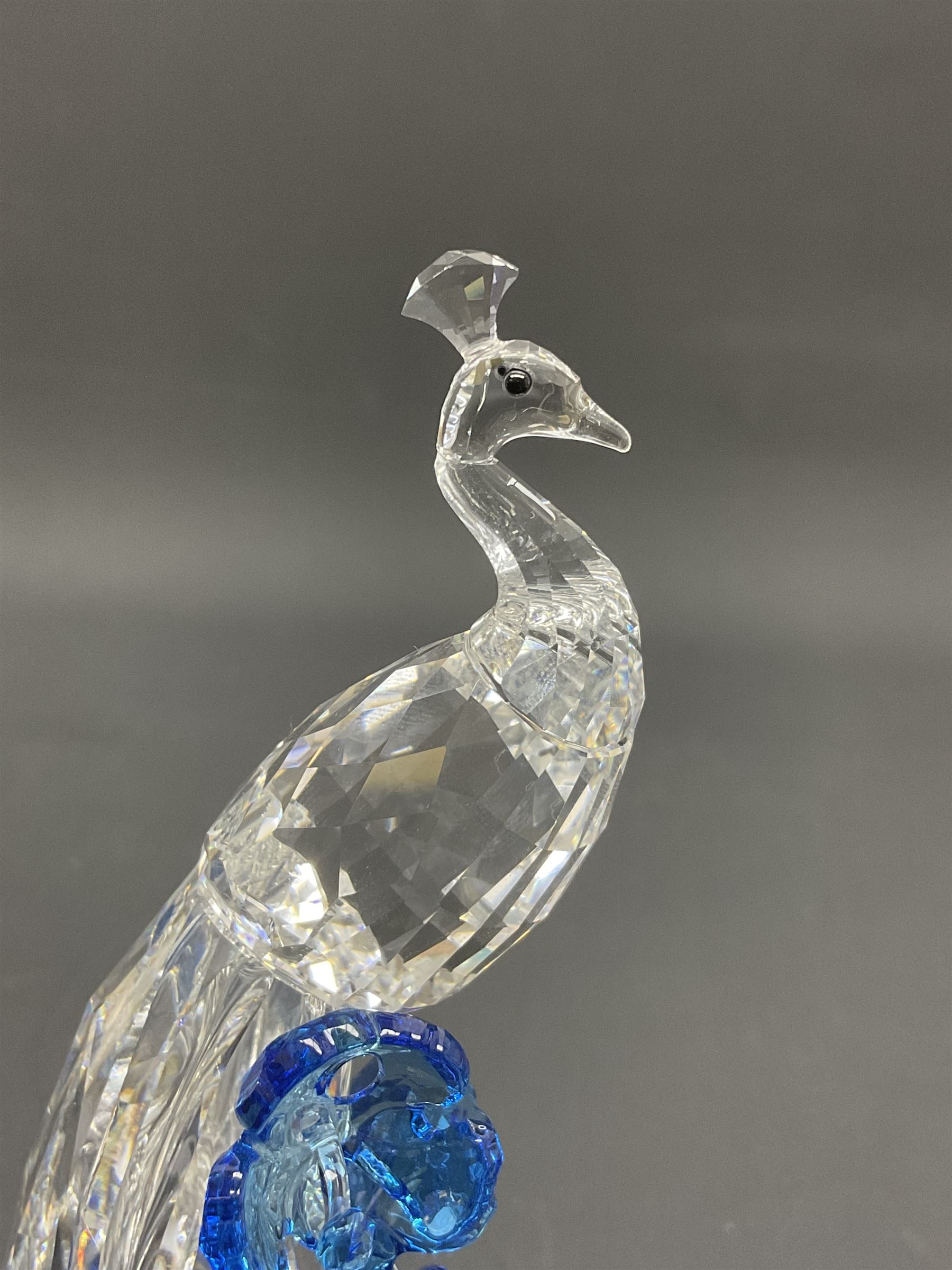 Swarovski Crystal animals, comprising white peacock, the tail with cascading blue flowers, perched eagle with yellow beak, ibex with frosted crystal horns and unicorn with frosted crystal horn, tallest H13cm