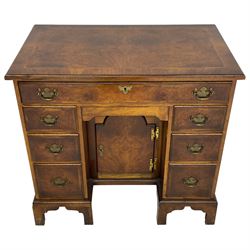 Georgian design figured walnut knee-hole desk, the rectangular moulded top with crossband, fitted with frieze drawer over six smaller drawers with oak linings, recessed cupboard enclosed by stepped arch mould door, on bracket feet