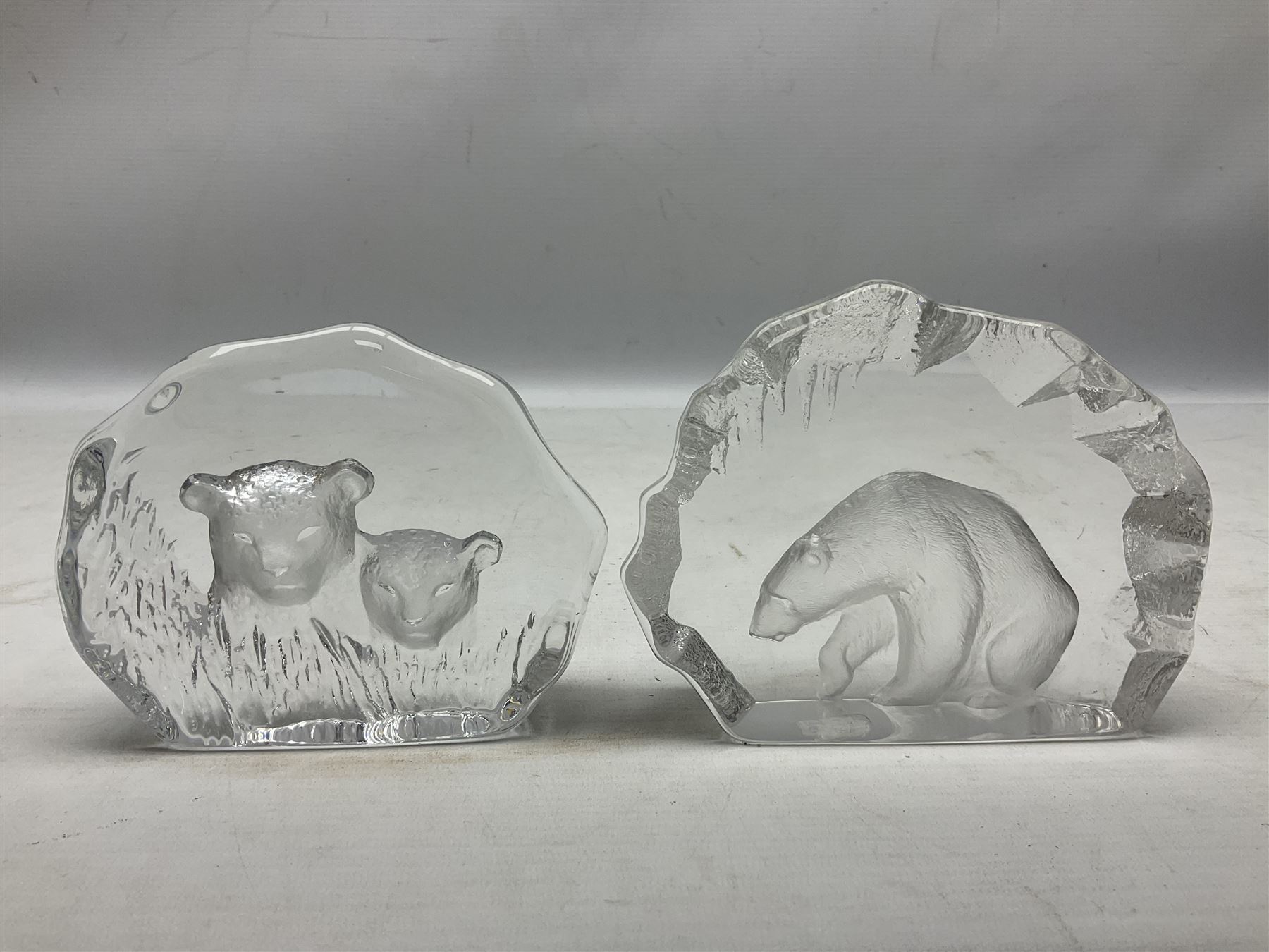 Two Mats Jonasson, Sweden paperweights, comprising polar bear in ice cave no 3152 and lion cubs, both with etched marks beneath, tallest H11.5cm