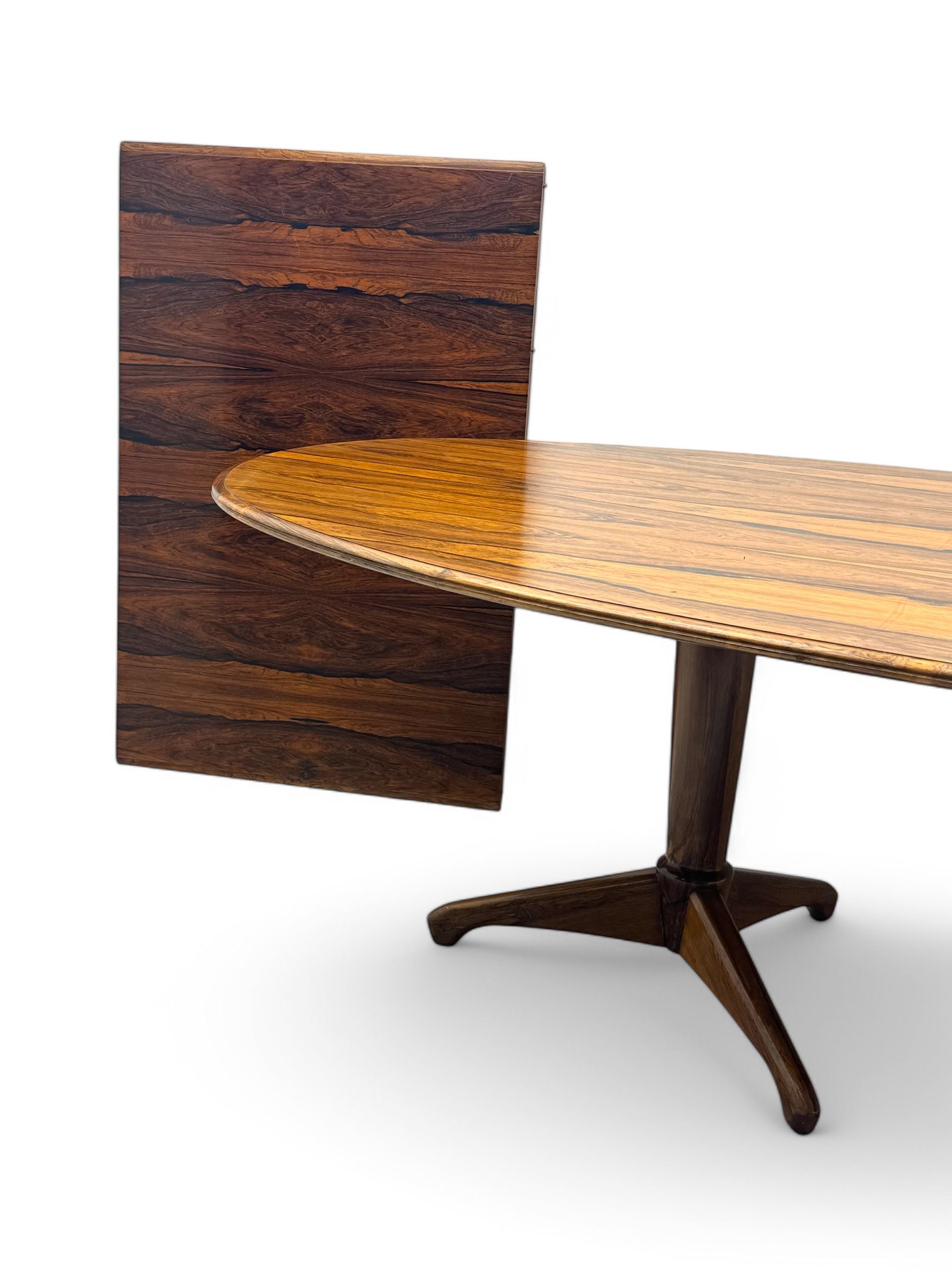 Andrew Milne for Heals - mid-20th century extending dining or boardroom table, oval top with one additional leaf, raised on twin tapering pedestal supports terminating in tripod feet