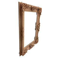 Rectangular wall mirror, in ornate pale pink painted frame decorated with scrolled foliage, flower head and shell motifs, bevelled plate