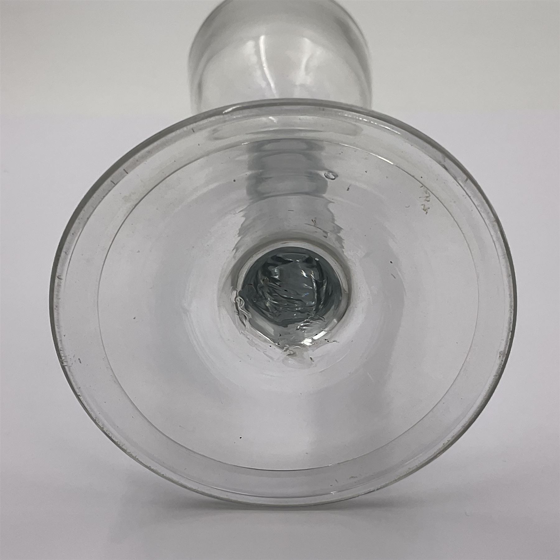 Three 18th century wine glasses comprising a plain stemmed glass with bell shaped bowl and conical folded foot H16cm, another plain stemmed glass with ogee bowl and folded foot and a Continental glass with gilt faceted bowl, decorated with male figure within a landscape, on a clear Silesian seven sided cut stem (3)