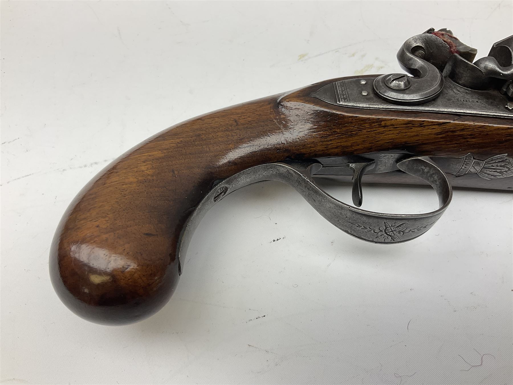 Early 19th century flintlock 16-bore overcoat/duelling pistol by William Bond Lombard Street London, the 23cm octagonal brown stub twist damascus barrel with small foresight, two barrel pins and ram rod under, inscribed Lombard Street London to the top and W. Bond to the action, full walnut stock with lightly engraved steel furniture, pineapple finial and escutcheon, half cock facility L39cm; loose mounted on later mahogany display stand with trade label