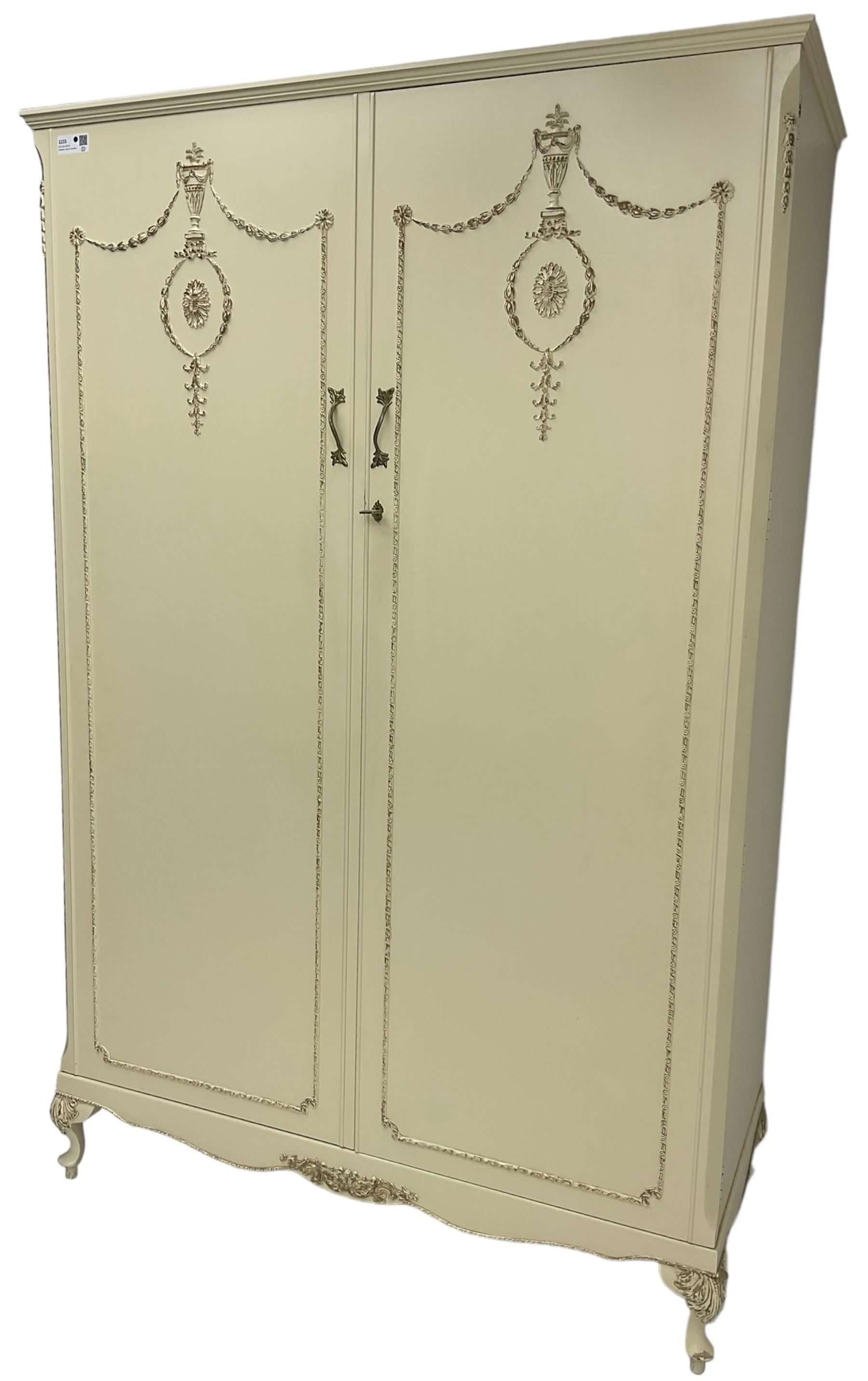 French classic design cream painted double wardrobe, the doors decorated with gilt and cream applied urn motifs with extending bell-flower festoons and ribbon twists, enclosing shelf and hanging rail, shaped apron on acanthus cabriole feet