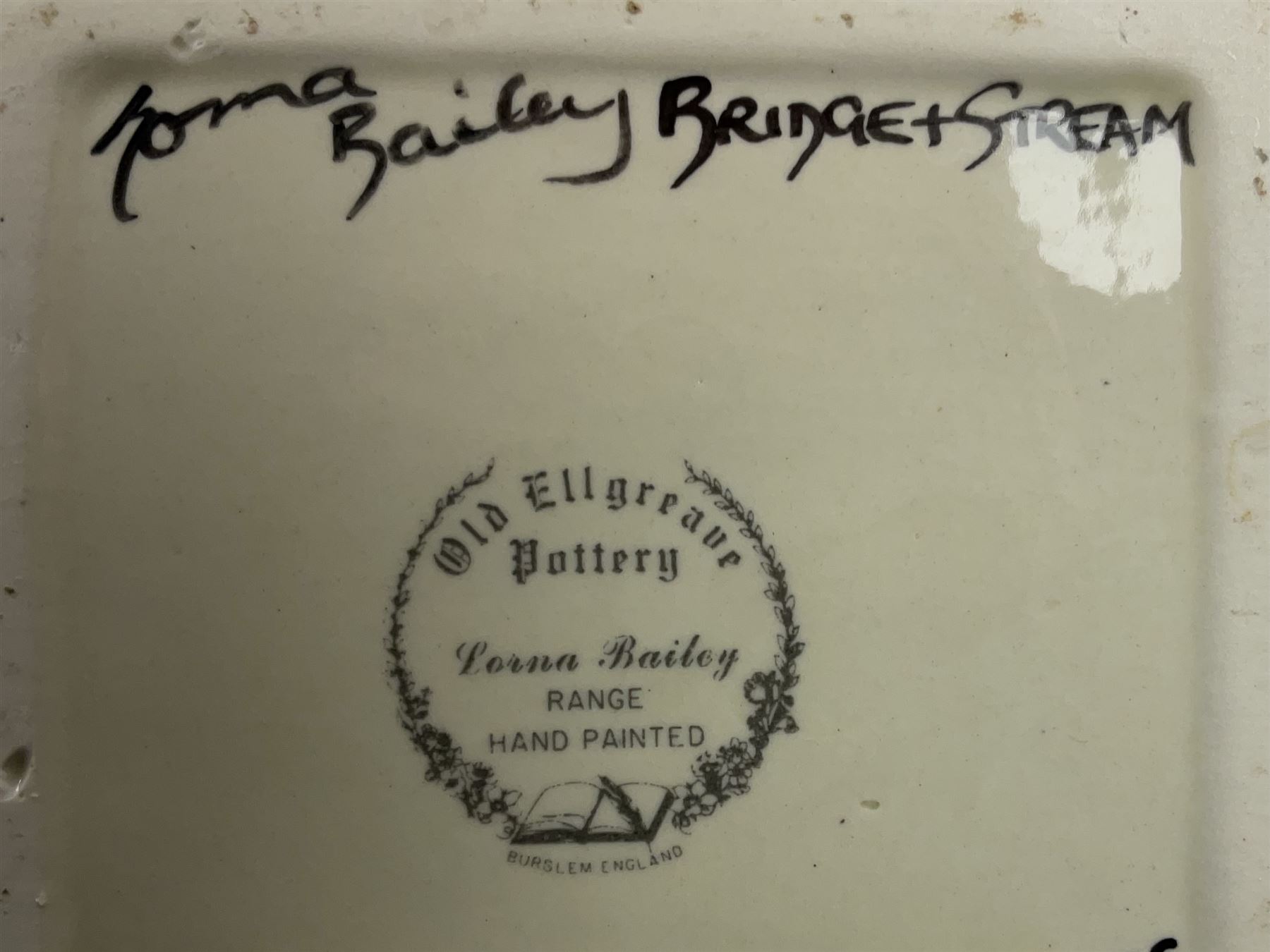 Lorna Bailey Old Ellgreave Pottery, comprising teapot in beach design, circular jar in house and path design, shell jug in Bridge and stream design, squat jug in Pagoda design and plate decorated with an Art Deco woman, all with printed and painted marks. 
