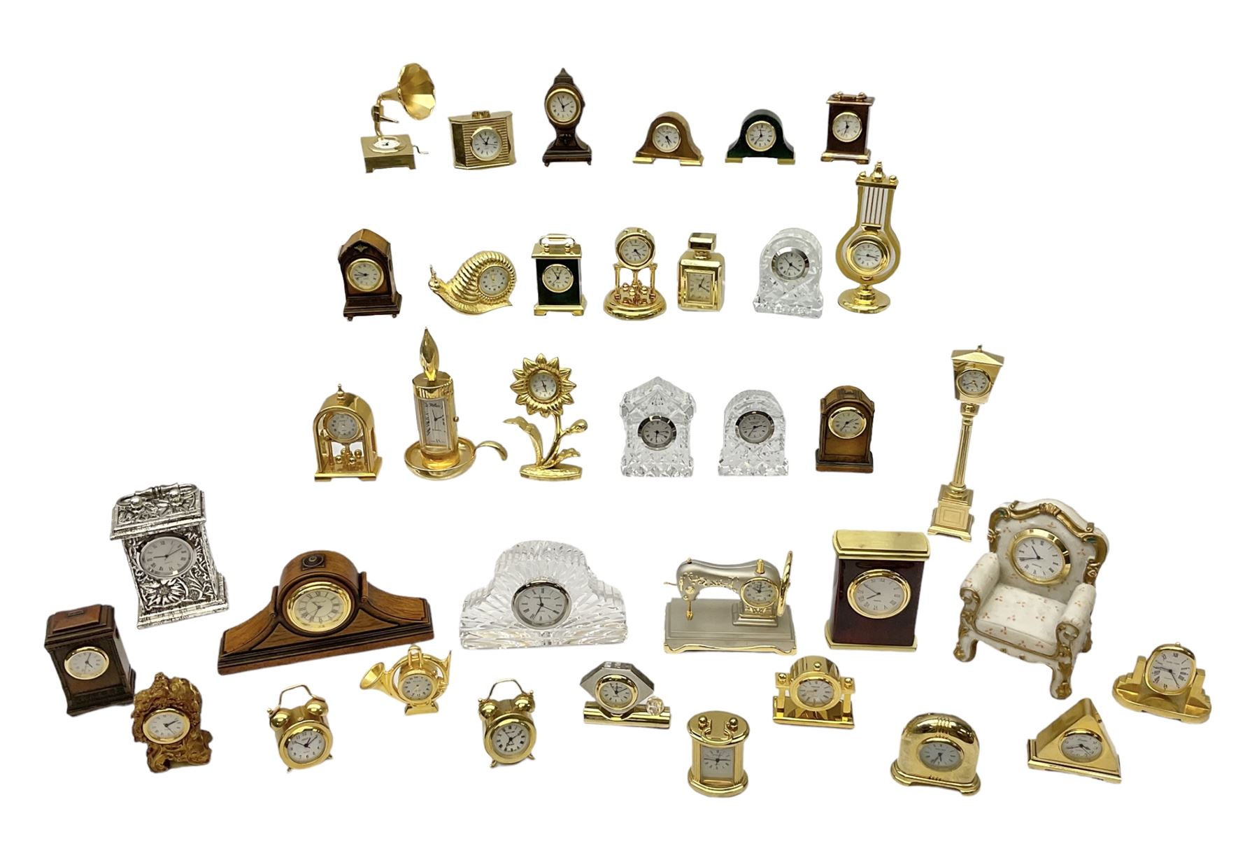 Collection of miniature clocks, predominantly with quartz movements, to include example modelled as an armchair, Edinburgh crystal glass example, clock modelled as a flower, sewing machine etc