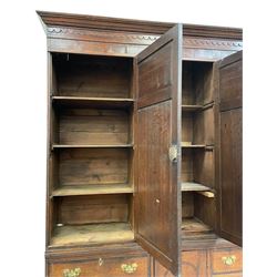 Large George III oak and mahogany banded housekeepers cupboard, projecting cornice over fretwork decorated frieze, three panelled doors enclosing small drawers and shelves, the lower section fitted with six drawers and central cupboard, on bracket feet