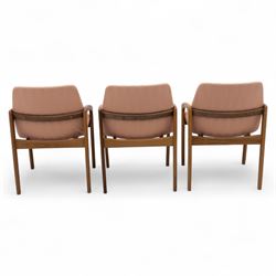 Mid-20th century Danish teak armchairs, each with curved open arms and upholstered seat and backrest in salmon pink striped fabric, raised on tapering legs