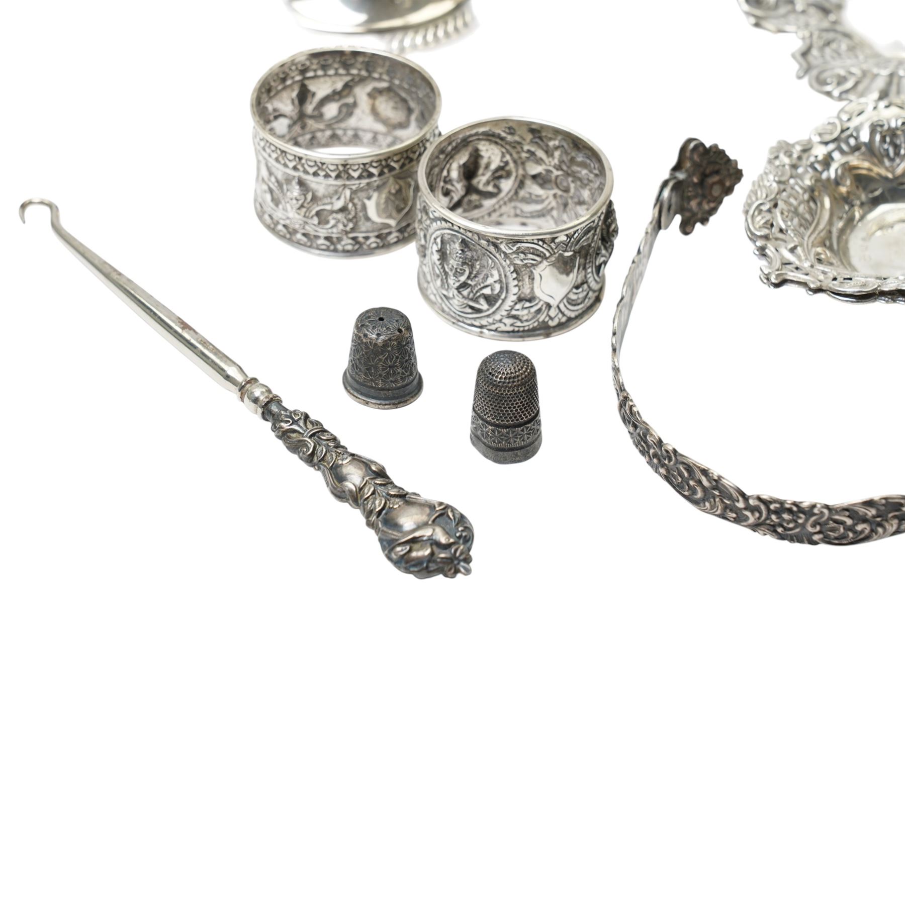 Two Indian white metal napkin rings, sterling silver candlestick, pair of silver heart shape sweetmeat dishes Chester 1895, single sweetmeat dish and other items