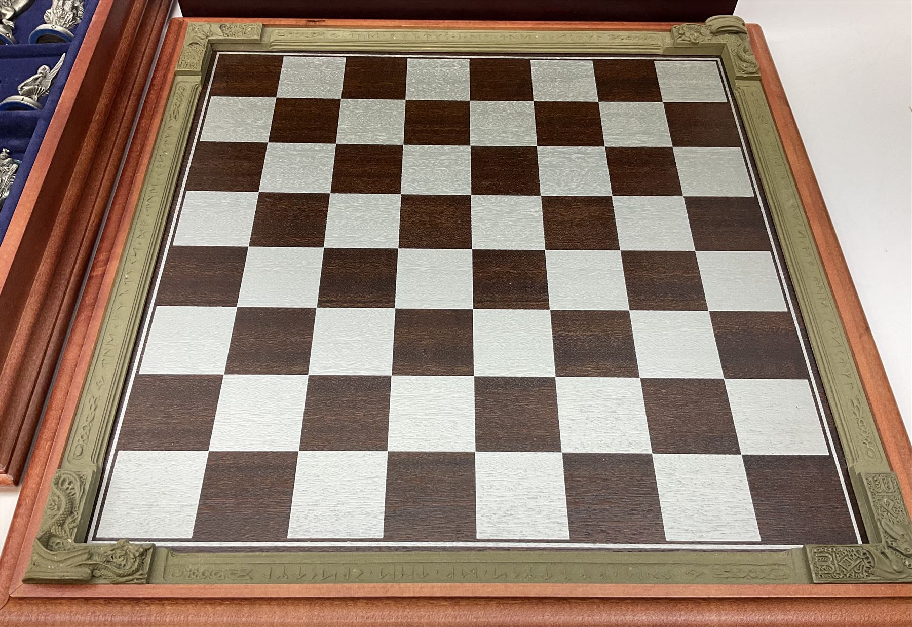 Danbury Mint 'The Fantasy of the Crystal' chess set consisting of mythical pewter chess pieces within a wooden case with chess board lid, together with 16 additional chess pieces in a wooden display case.