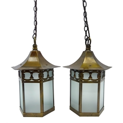  Pair of Arts & Crafts oxidised brass hexagonal porch lanterns, retailed by Harrods circa 1910, frosted glazed sides, pierced border beneath a conforming Pagoda style top, converted with later fittings, H28cm (excluding suspension loop)  