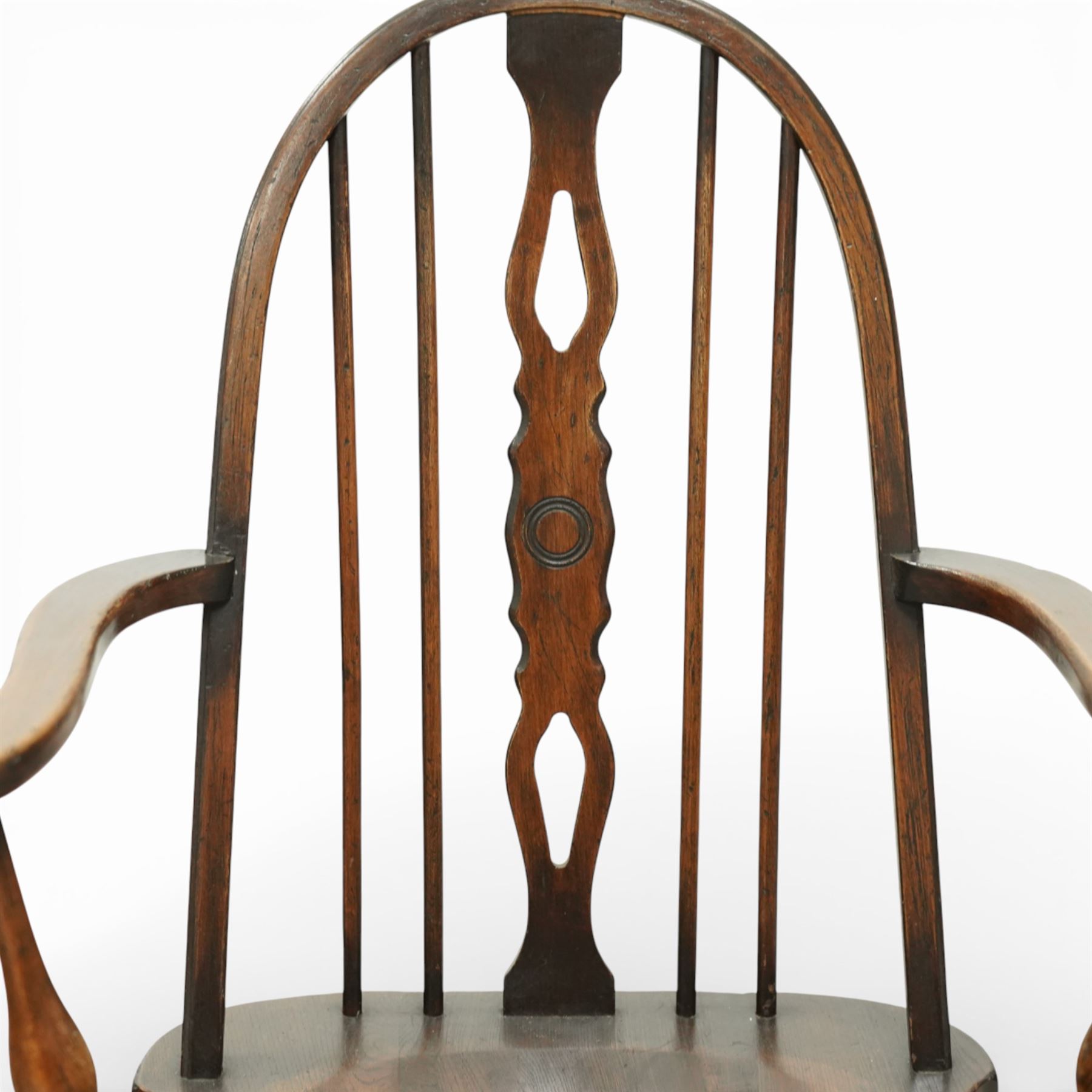 Early 20th century Windsor armchair, the arched hoop back enclosing a pierced and shaped splat flanked by turned spindles, above a shaped elm seat and outswept arms on turned supports, raised on turned legs united by an H stretcher
