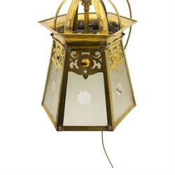 Arts & Crafts brass hall lantern, circa 1900, of hexagonal tapering form with open dome top support and pierced foliate detail above frosted glass panels with flower head detail, H41.5cm D29cm