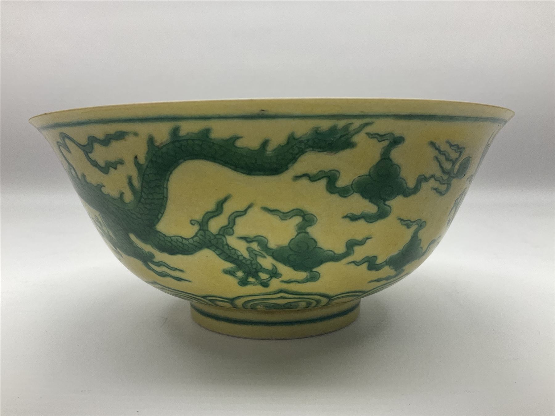 Pair of Chinese famille jaune bowls, decorated in green enamel with a dragon chasing a flaming pearl amongst clouds, upon a yellow ground, the interior decorated to centre with dragon, with six character mark beneath, D17.5cm
