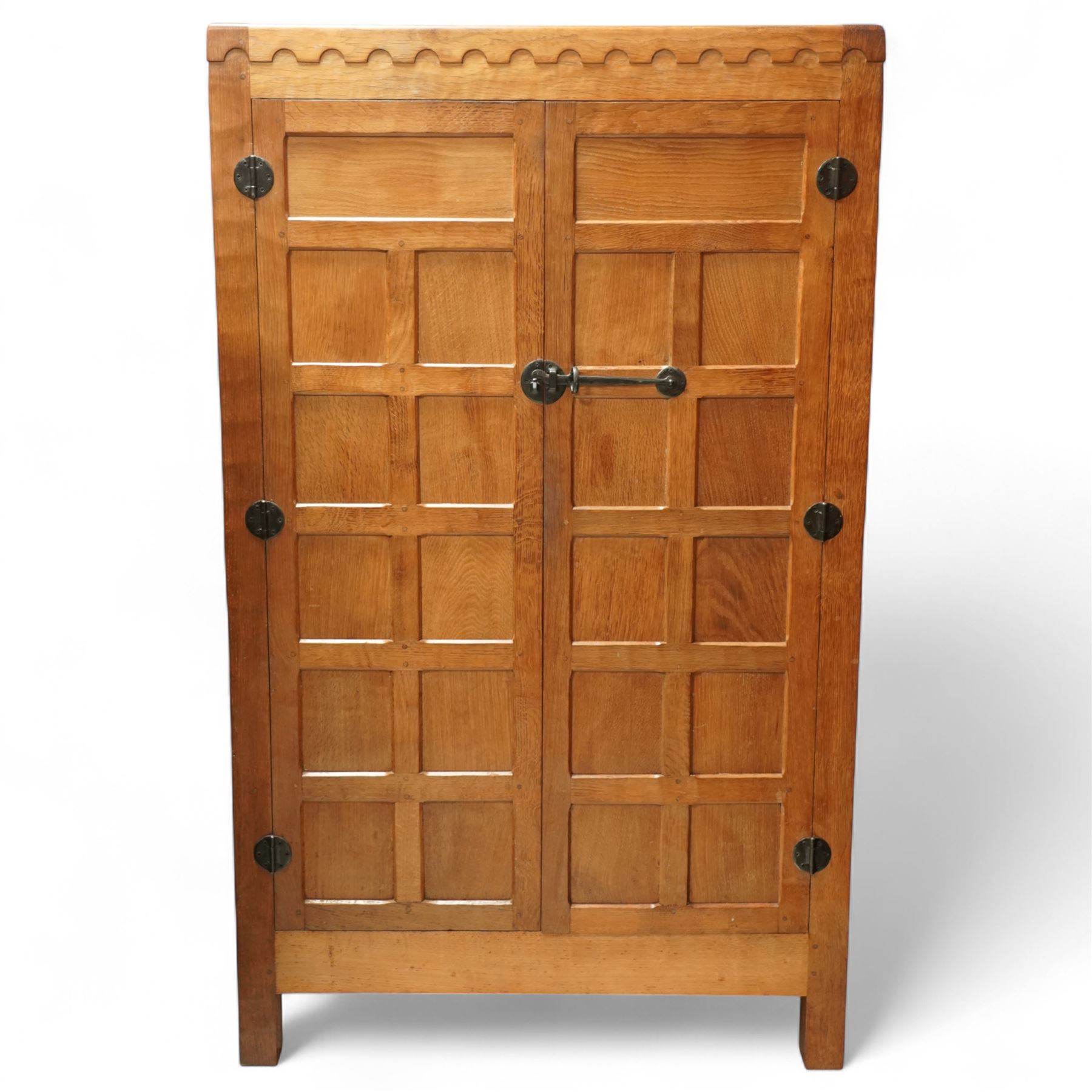 Mouseman - Oak 5' x 3' wardrobe, circa 1950s, scalloped cornice, panelled sides and front, twin doors with wrought metal latch and hinges, raised on stile supports with carved mouse to left hand side, by the workshop of Robert Thompson, Kilburn

Provenance - this lot comes to us for sale from direct descent of Robert Thompson. Thompson is the great grandfather of the vendor.
