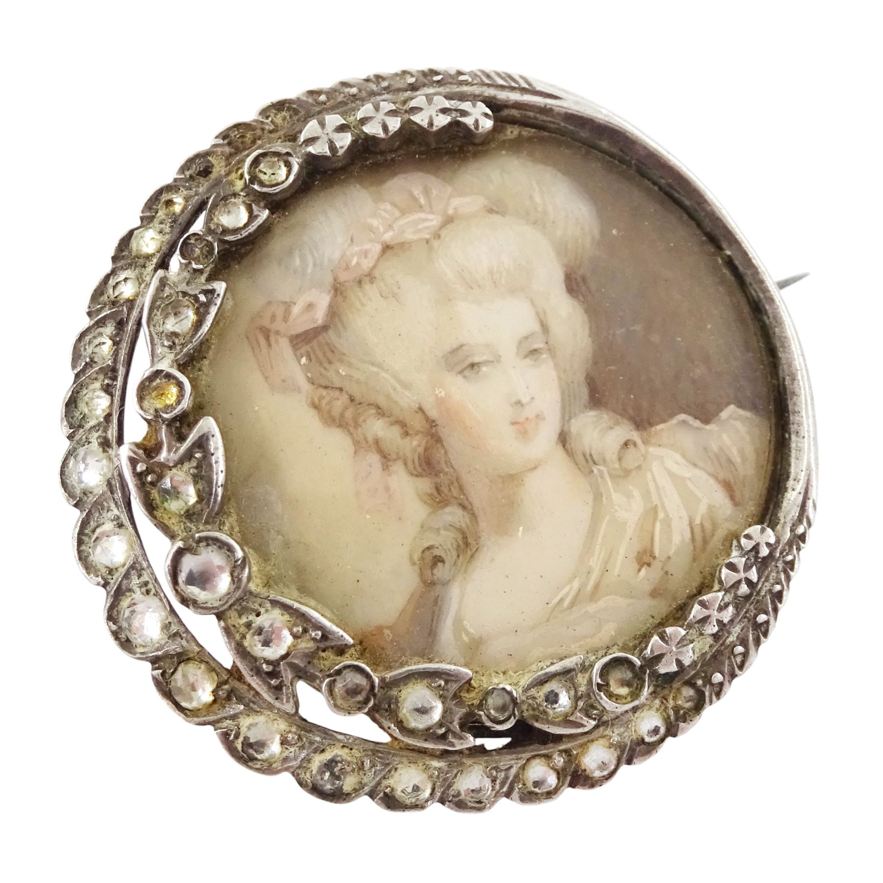 Three 19th century silver portrait brooches, each set with miniatures of women in 18th century dress on ivory, two with seed pearl surrounds and the other within a foliate paste set surround. This lot has been registered for sale under Section 10 of the APHA Ivory Act