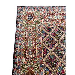 Persian Kirman indigo ground carpet, the field with repeating lozenge tiles with overall floral decoration, the main border with floral panels enclosed by the guards