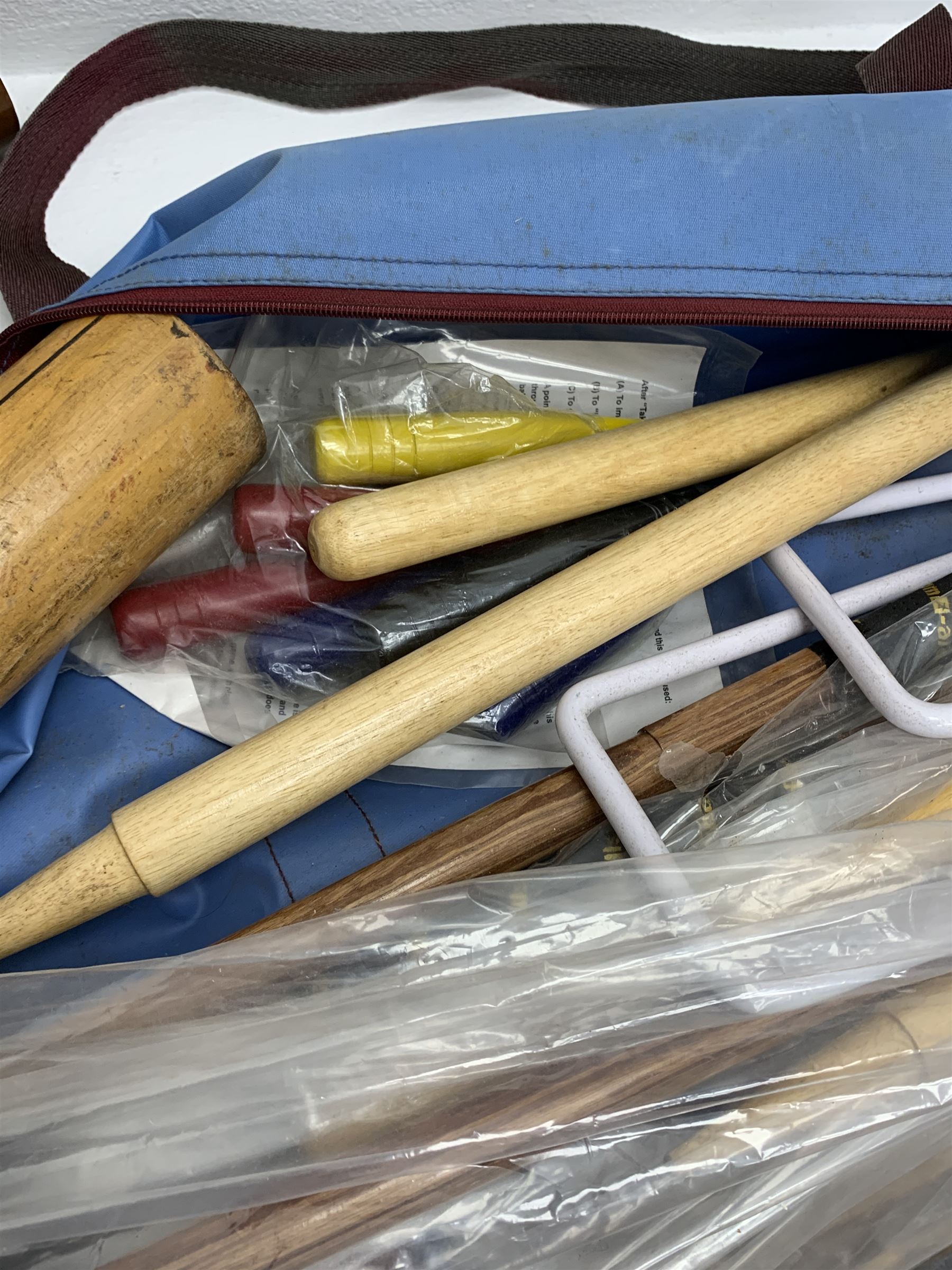 A croquet set, with wooden mallets, hoops, and balls, in carry bag