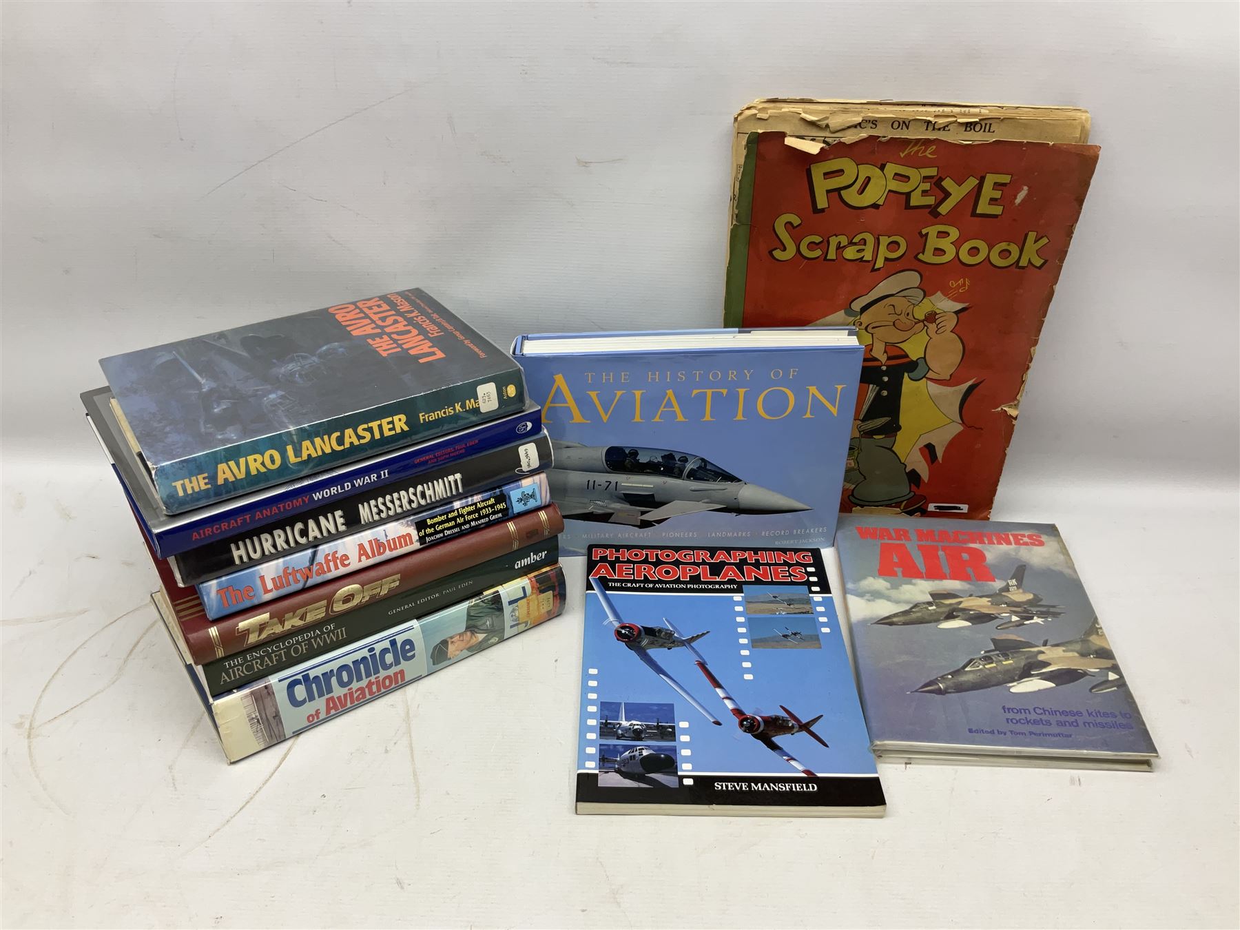 Ten books of predominantly military aircraft interest including Aircraft Anatomy World War Two, Hurricane Messerschmitt, The Avro Lancaster, The Luftwaffe Album, Encyclopaedia of Aircraft of WWII etc; together with a scrap album of WW2 newspaper cuttings