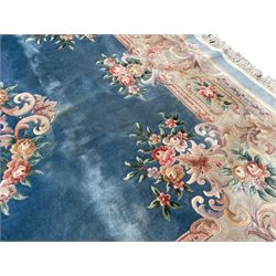 Large Chinese blue ground woollen carpet, overall floral design, central oval medallion surrounded by scrolling floral decoration, wide border with decorated with floral bouquets 