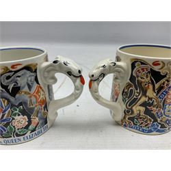 Two Dame Laura Knight coronation mugs for King George VI and Queen Elizabeth, comprising a Burleigh Ware example and a J&G Meakin example, each with a lion moulded handle and printed marks beneath, H8cm
