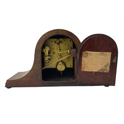 Sapele Mahogany cased tambour mantle clock c1950 with a three-train chiming movement, chiming the quarters on 5 gong rods, with a silvered dial, Arabic numerals, minute track and steel spade hands, strike/silent facility. With pendulum.



