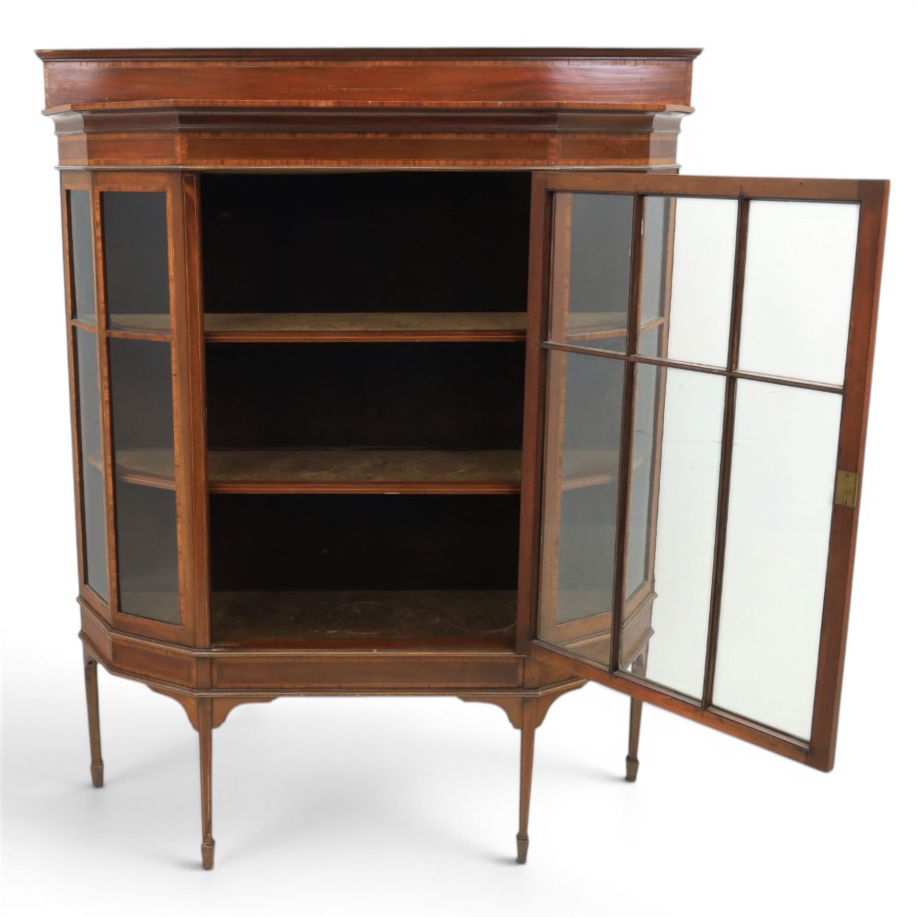 Edwardian inlaid mahogany display cabinet of rectangular canted form, galleried top with crossbanded inlay, above a glazed cabinet enclosing  baize lined shelves, raised on square tapering legs terminating in spade feet  