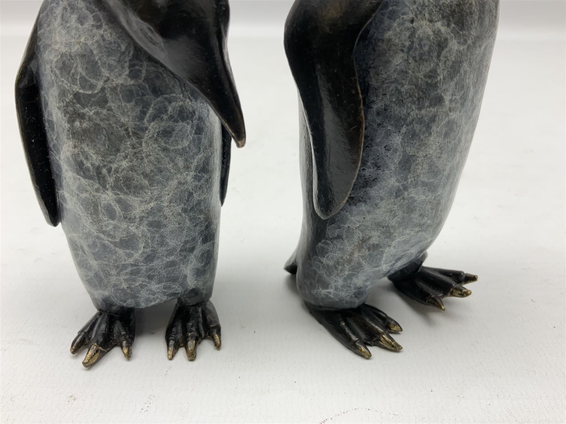 Steve Boss (British 1970-); Bronze figure group of a family of Emperor penguins, entitled Waddle, all with artists monogram beneath, tallest H12cm