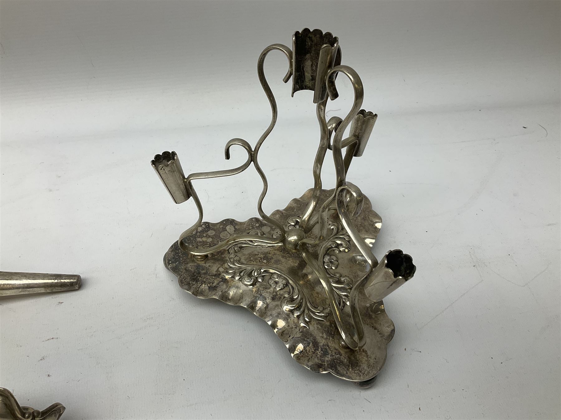 Four hallmarked silver trumpet vases, total weight 108g, upon silver plated stand with foliate decoration and bun feet