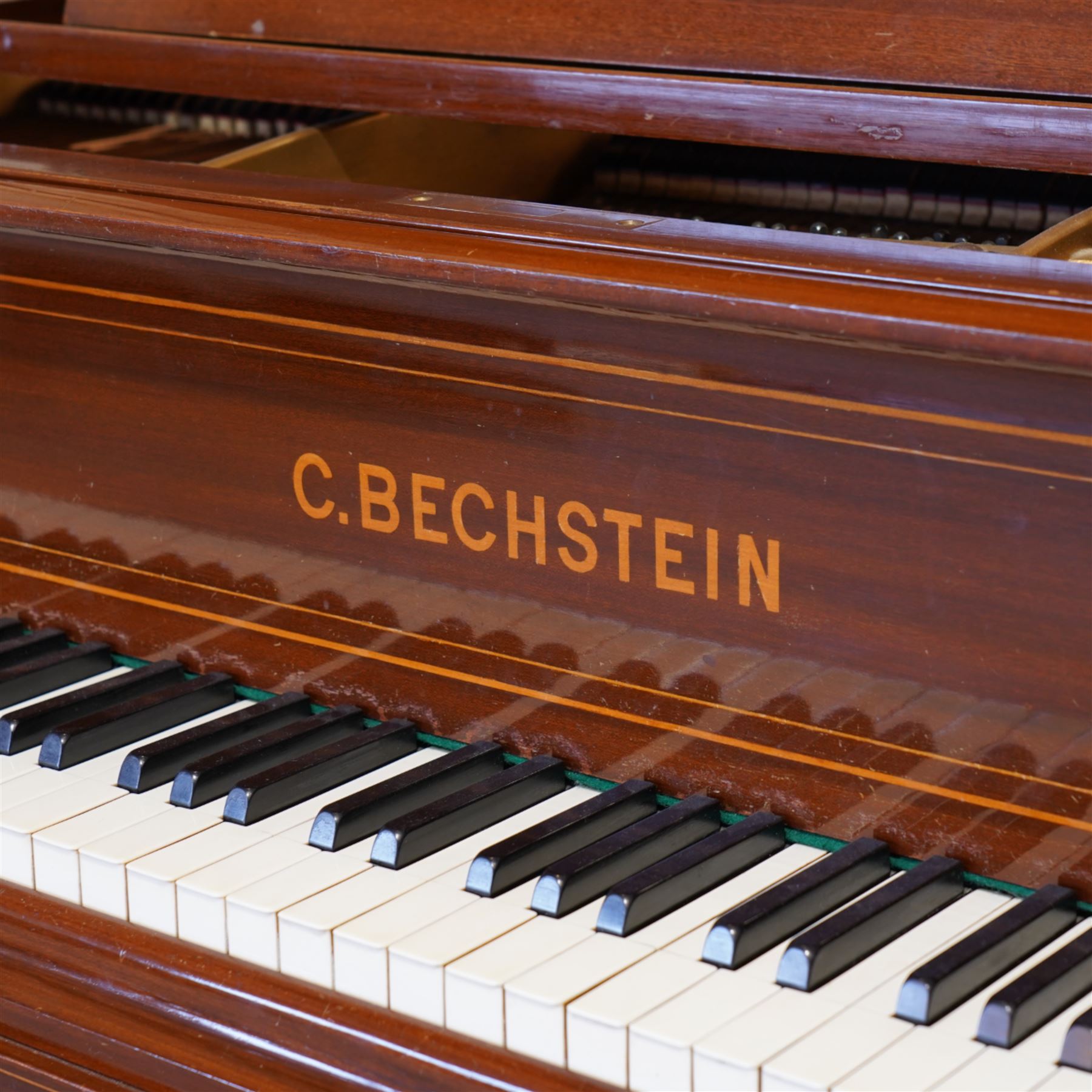 Carl Bechstein model A  grand piano serial No 44945 (1898), in a Sheraton revival mahogany case with inlaid satinwood stringing, overstrung cast iron frame raised on dual square tapering legs with brass castors, solid music desk and conforming lyre, 85 note (7 octave) A-A compass, sostenuto and sustain pedals, original action, hammers, dampers and stringing.

This item has been registered for sale under Section 10 of the APHA Ivory Act