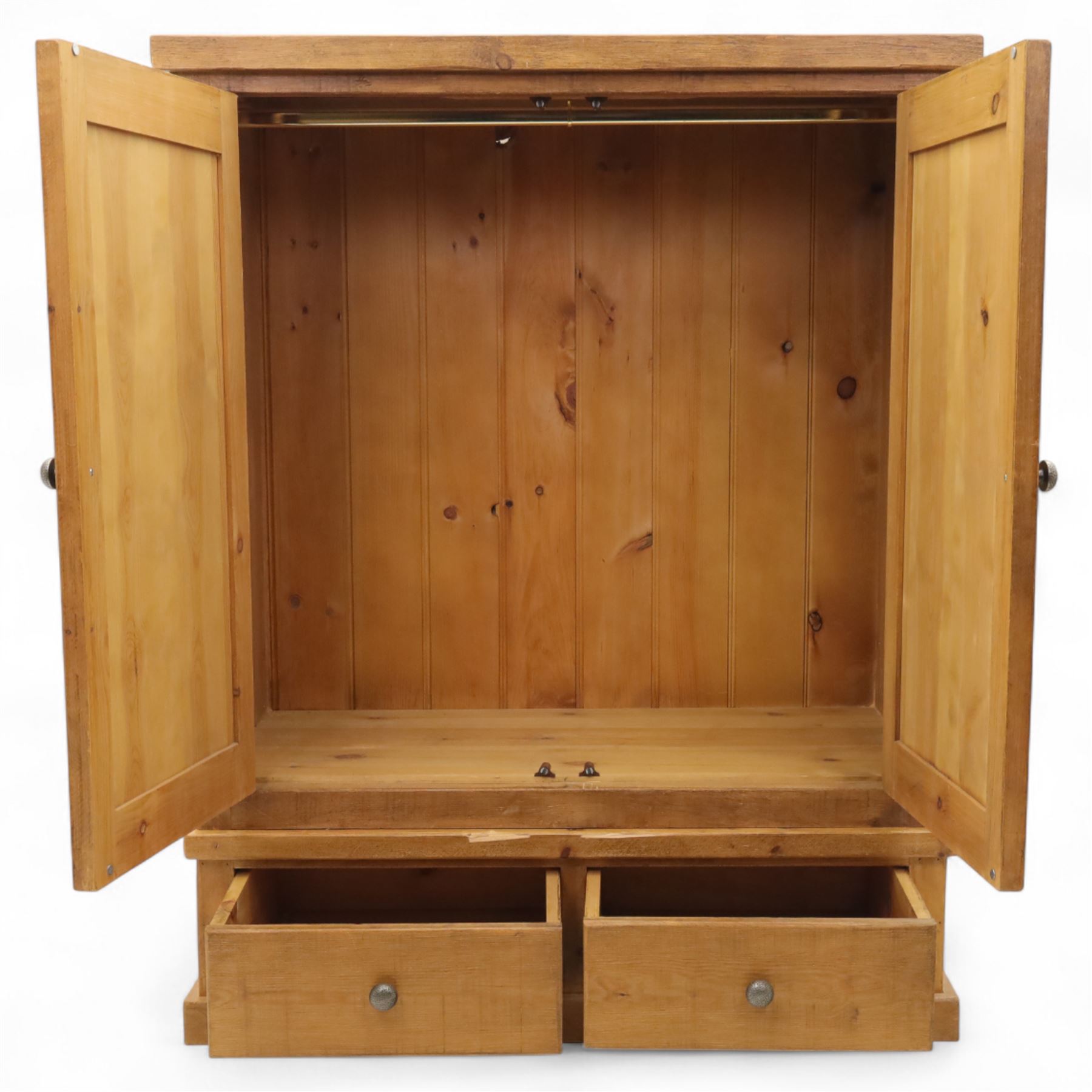Contemporary pine hanging wardrobe, twin panelled doors enclosing open hanging space with brass rail, two drawers to lower section, on moulded plinth base
