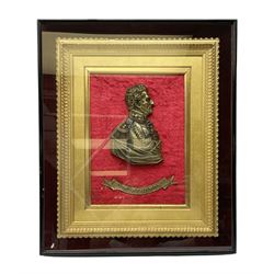 Late 19th/early 20th century cast brass head and shoulder profile of Wellington mounted with named brass banner on a red velvet ground in an ornate gilt frame within a glazed ebonised display case; bears labels verso for Maull & Fox 187a Piccadilly London W. 52 x 44cm overall