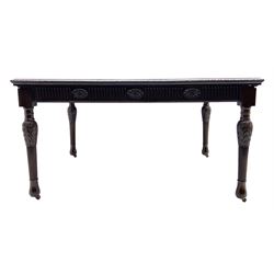 Early 20th century Hepplewhite style mahogany dining table, the rectangular top with foliate carved edge, fluted frieze rails carved with flower heads, turned and reeded acanthus supports with recessed castors