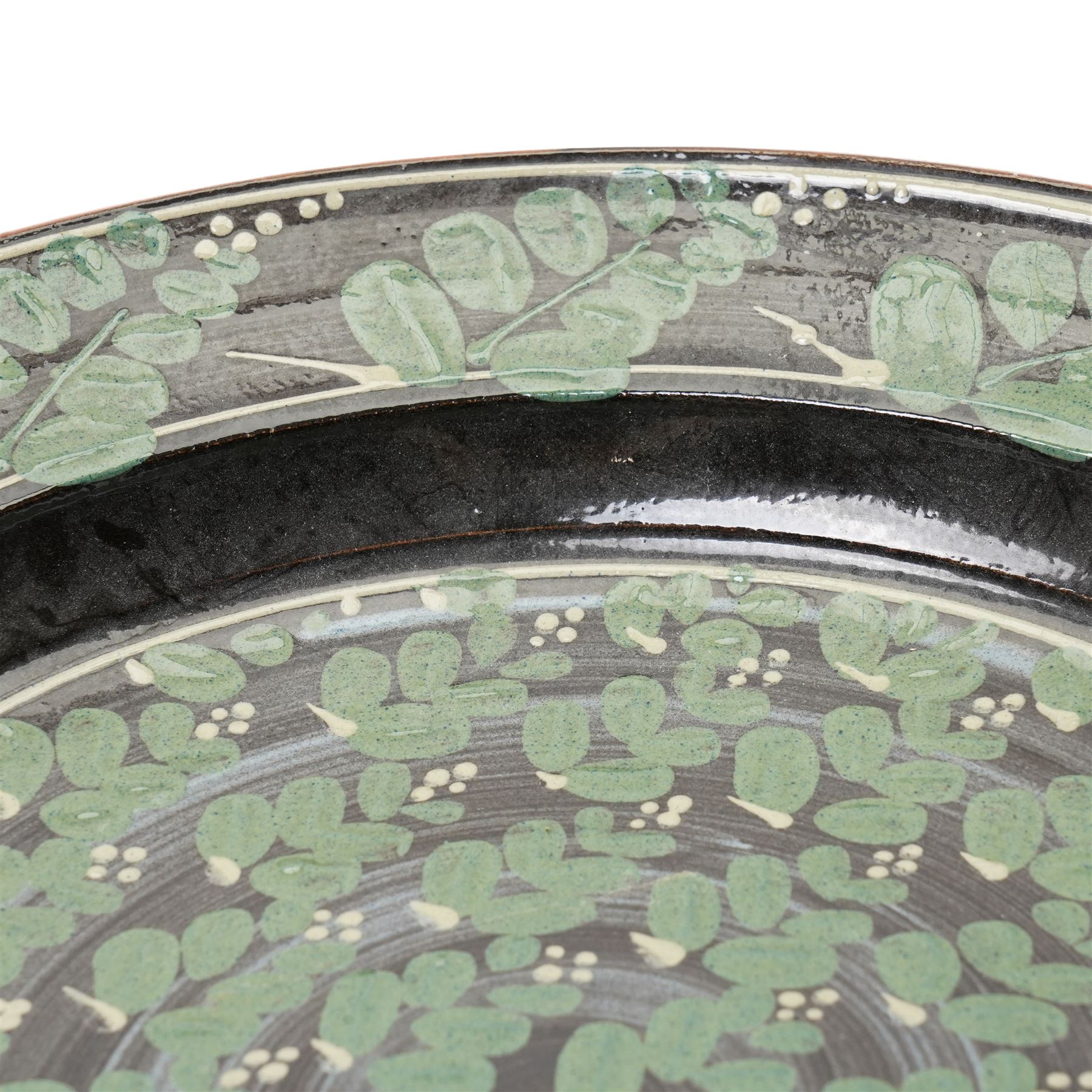 Richard Phethean (1953-): Slipware charger, decorated with green foliage on a black ground, D40cm 