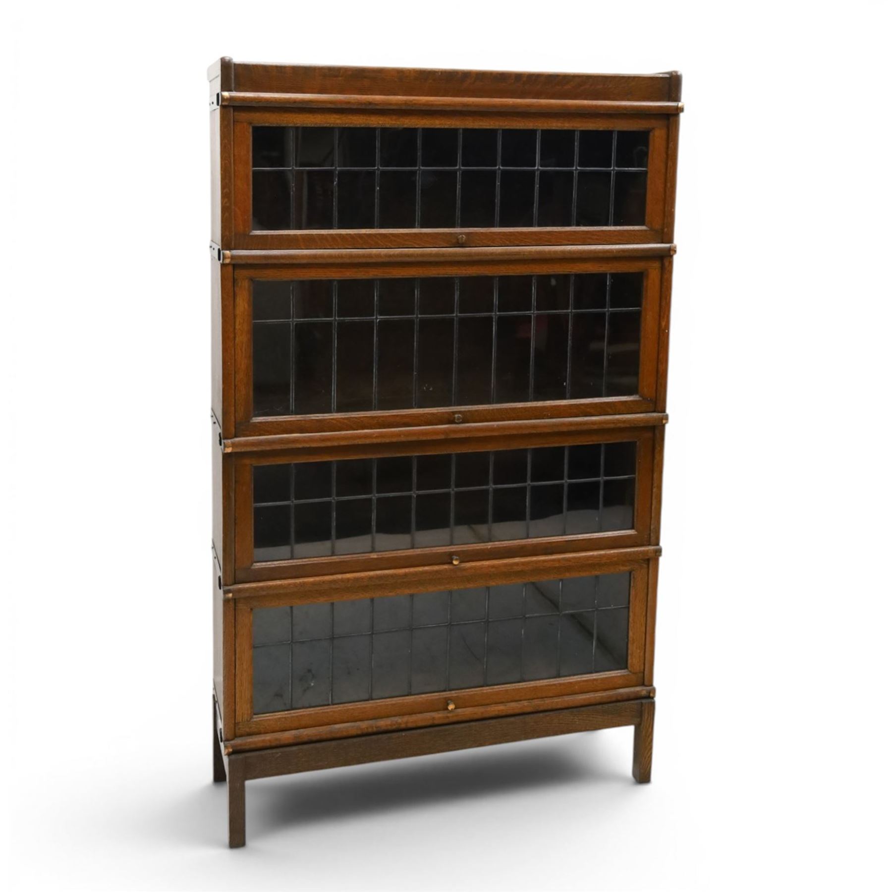 Globe Wernicke - oak four tier barrister bookcase, with leaded glazed fronts, raised on square supports