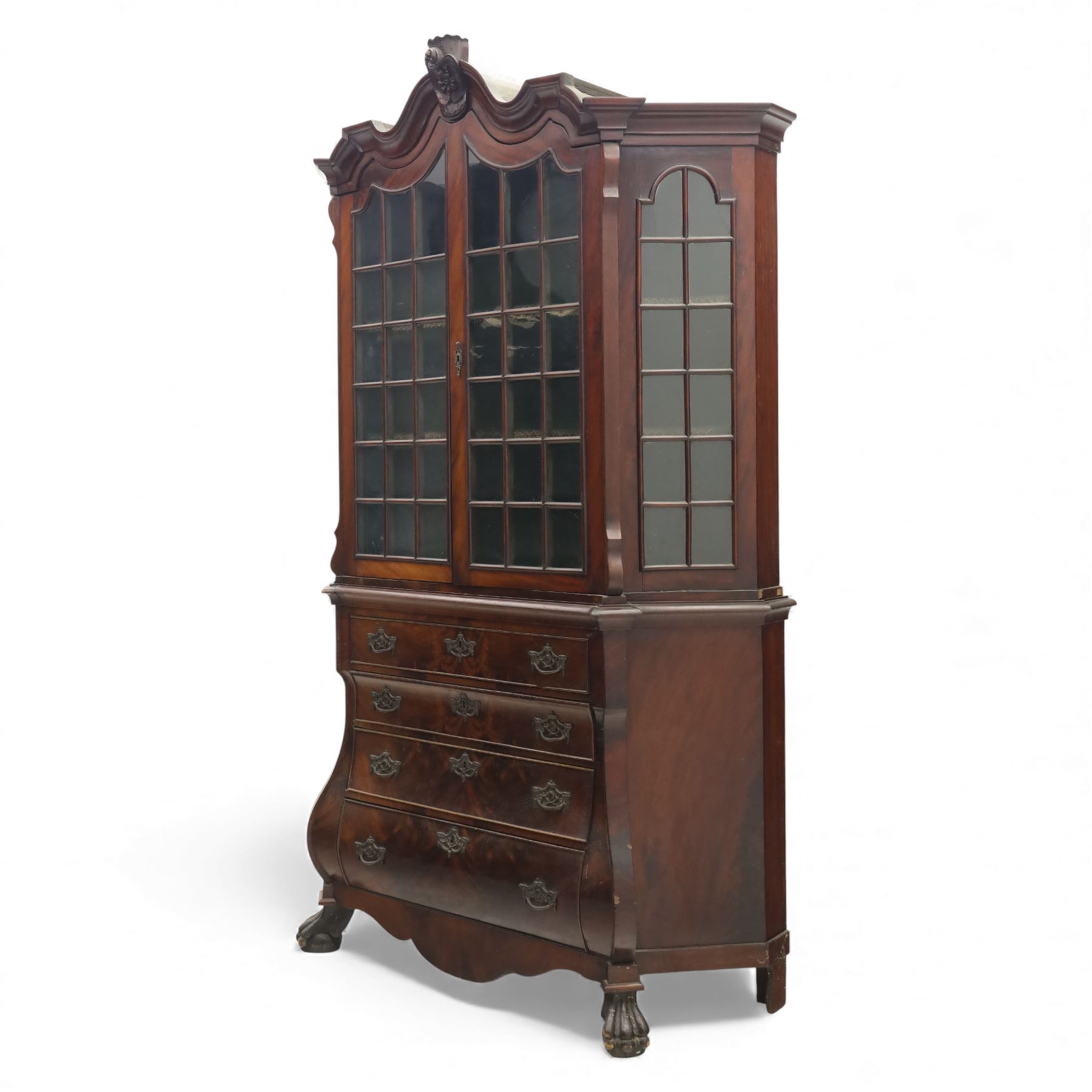 Late 19th century Continental bombe cabinet on chest, shaped moulded cornice with carved cresting, the upper section enclosed by a pair of arched glazed doors with astragal glazing revealing a shelved interior, the lower section fitted with four graduating drawers with rococo-style metal handles, serpentine front and sides, raised on scroll and paw feet