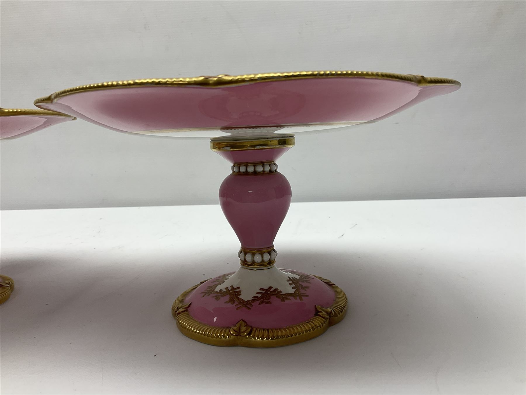 Victorian dessert service, comprising four comports and nine plates, each decorated with floral sprigs to the centre with a pink and gilt border, largest comport H13cm, plate D22.5cm