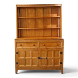 Rabbitman - adzed oak Welsh dresser, scalloped cornice above two plate racks, adzed and panelled sides, the lower integrated section with adzed oak top, over two drawers above twin cupboard doors with blackened metal latch and hinges, carved rabbit to the right hand side, by Peter Heap of Wetwang